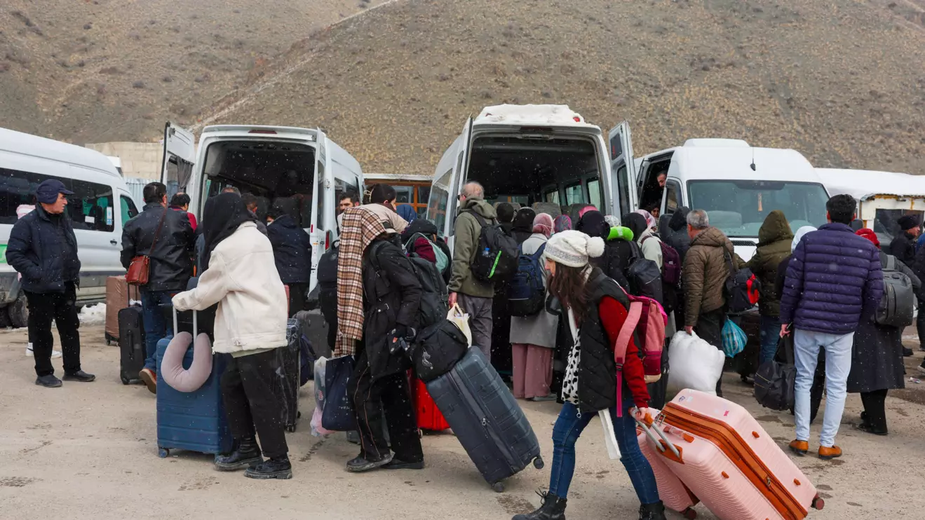 People wait for transportation to the city center after crossing from Iran into Turkey at the Kapikoy Border Gate in eastern Van province, Turkey, March 2, 2026. Reuters/Dilara Senkaya