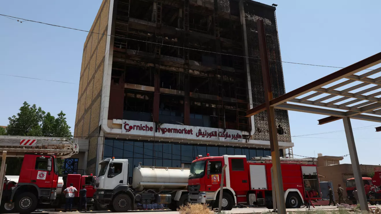 Fire trucks stand next to the wreckage of a shopping center, after a massive overnight fire killed dozens of people, in al-Kut, Wasit province, Iraq, July 17, 2025. Reuters/Ahmed Saad