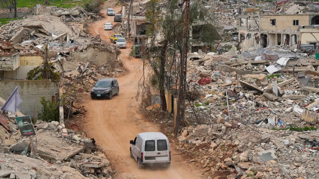 Cars drive past damaged buildings, after Israeli troops withdrew from most of south Lebanon, in Mays al-Jabal, near the border with Israel, southern Lebanon, February 19, 2025. Reuters/Mohammed Yassin