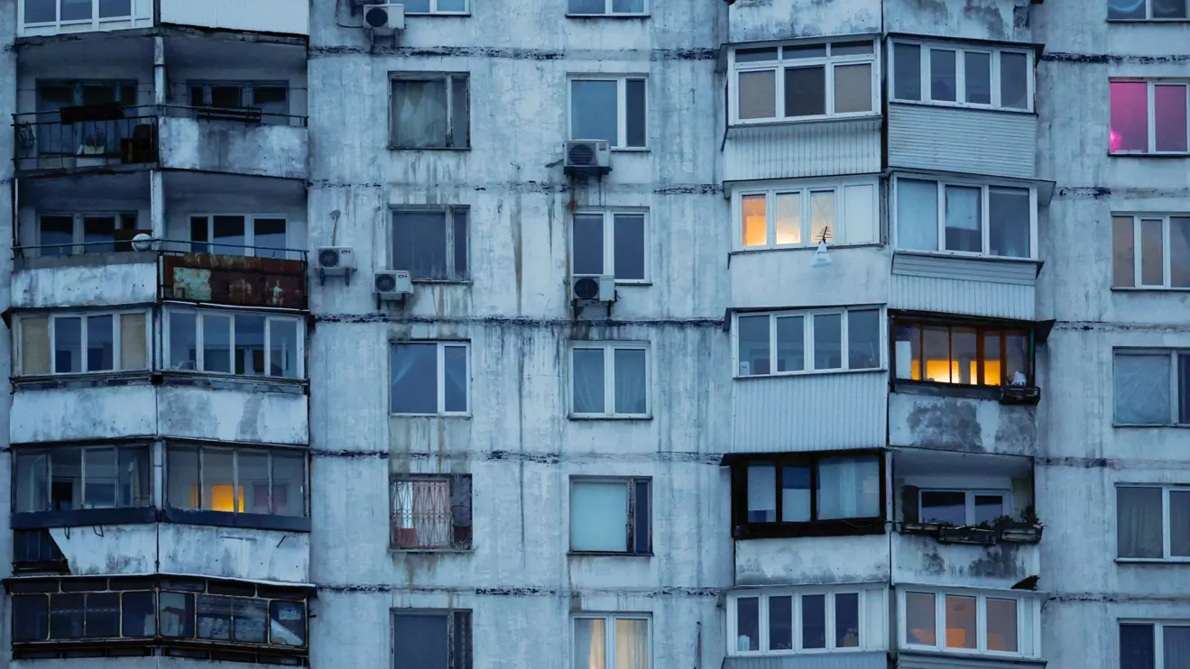 Some windows glow in a residential building left without heating and facing long power cuts after critical civil infrastructure was hit by recent Russian missile and drone strikes, amid Russia’s attack on Ukraine, in Kyiv, Ukraine, January 23, 2026. Reuters/Alina Smutko