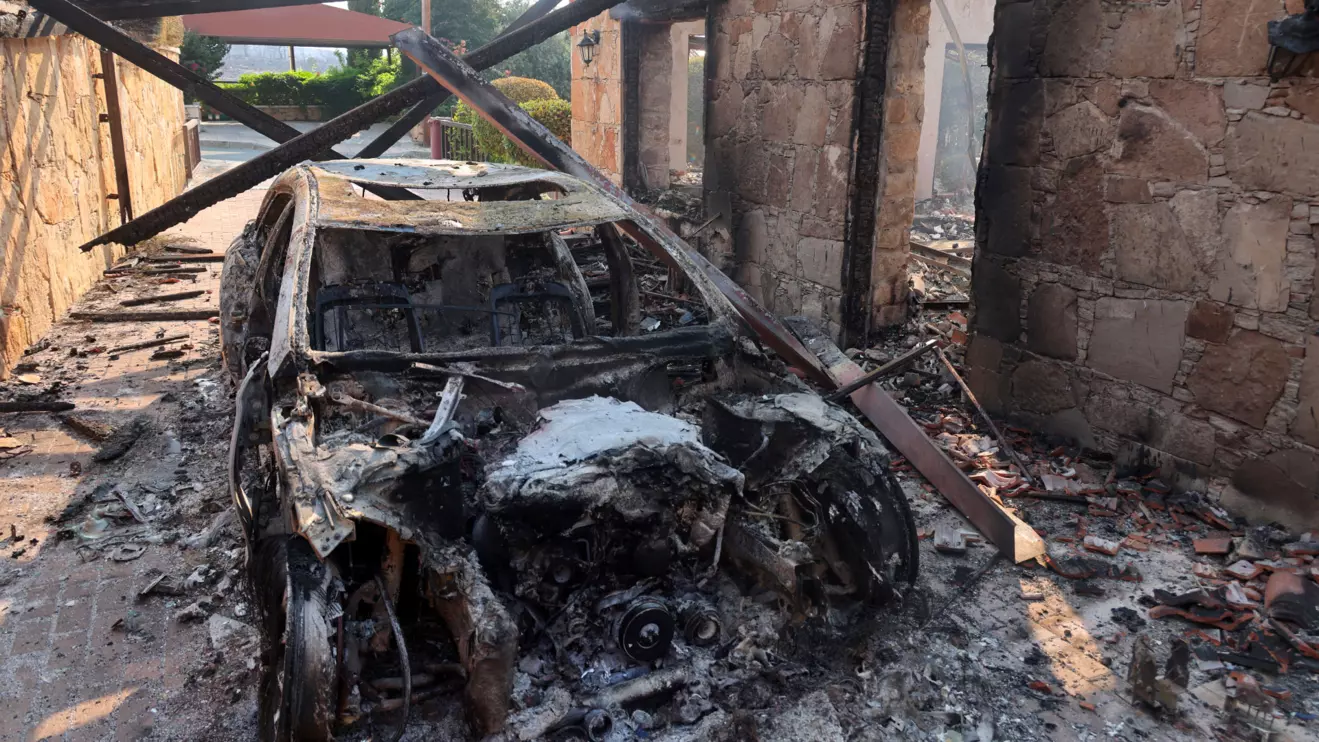 A burnt car is seen, as a wildfire burns in the village of Souni, near Limassol, Cyprus July 24, 2025. Reuters/Yiannis Kourtoglou