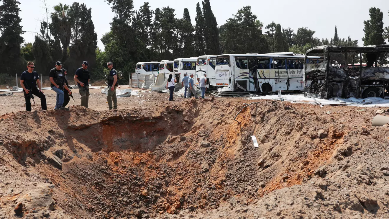 Police officers stand next to a crater at an impact site following a missile attack from Iran, in Herzliya, Israel, June 17, 2025. Reuters/Ronen Zvulun