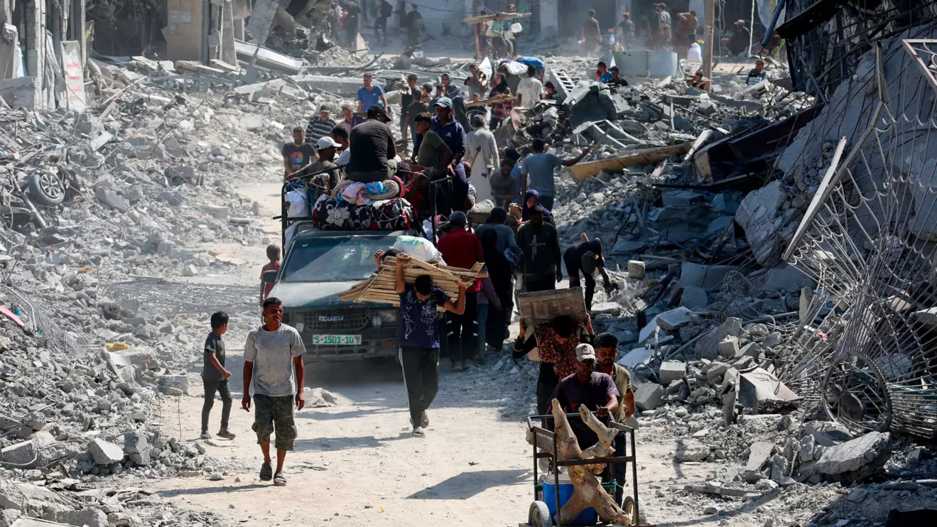 Palestinians walk past the rubble following Israeli forces' withdrawal from the area, after Israel and Hamas agreed on the Gaza ceasefire, in Khan Younis, in the southern Gaza Strip, October 10, 2025. Reuters/Ramadan Abed