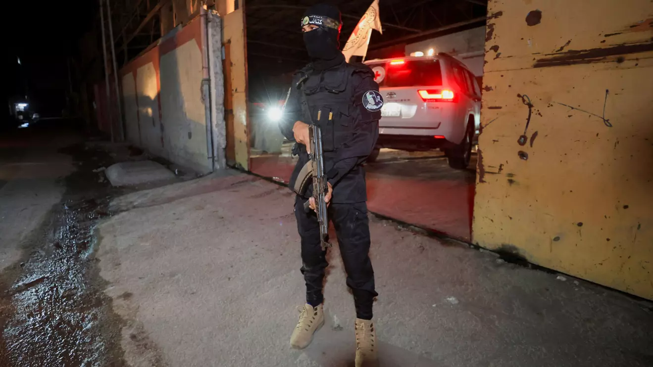 An armed Hamas militant stands guard as a Red Cross vehicle arrives to receive from Hamas militants the bodies of deceased hostages who had been held in Gaza since the deadly October 7, 2023 attack, as part of a ceasefire and a hostages-prisoners swap deal between Hamas and Israel, in Gaza City, October 14, 2025. ReutersDawoud Abu Alkas