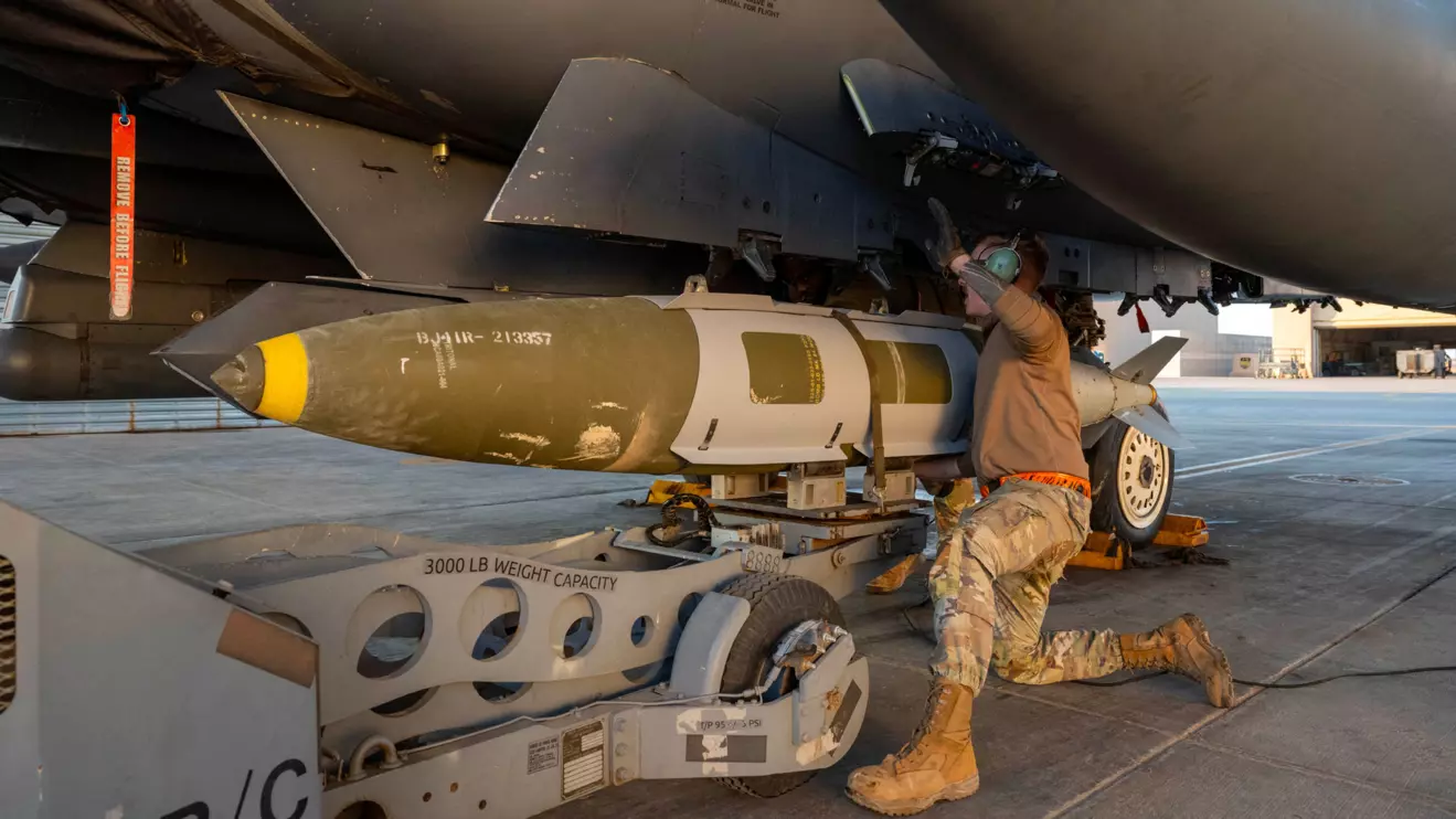 A U.S. Airman attaches a GBU-31 munitions system to an F-15E Strike Eagle in the U.S. Central Command area of responsibility, December 19, 2025, in support of Operation Hawkeye Strike as the U.S. military launched large-scale strikes against dozens of Islamic State targets in Syria in retaliation for an attack on U.S. personnel, U.S. officials said. U.S. Air Force Photo