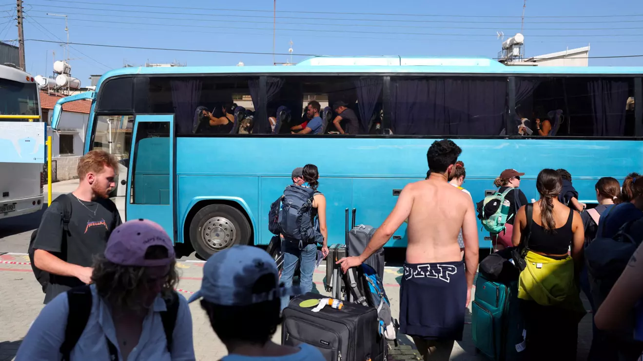Passengers, who had left Israel on Tuesday aboard the Crown Iris cruise ship due to the closure of Israel's airspace amid the Israel-Iran air war, board a bus after their arrival at the port of Larnaca, Cyprus, June 18, 2025. Reuters/Yiannis Kourtoglou