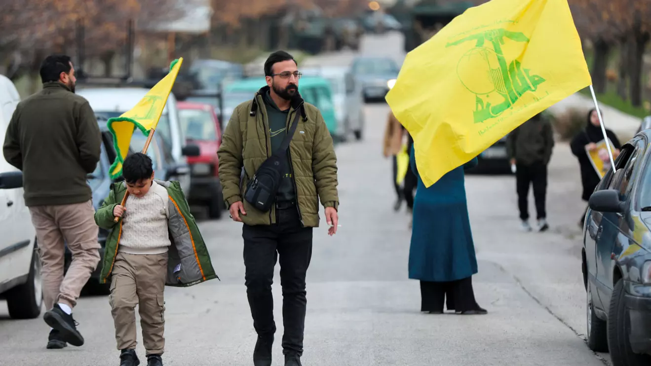 A boy walks as he holds a Hezbollah flag in Burj al-Muluk, near the southern Lebanese village of Kfar Kila, where Israeli forces remained on the ground after a deadline for their withdrawal passed as residents sought to return to homes in the border area, Lebanon January 26, 2025. Reuters/Karamallah Daher