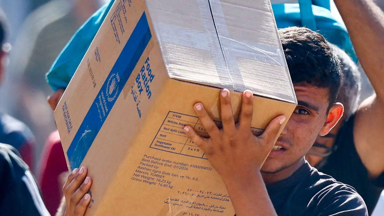 A Palestinian carries aid supplies that entered Gaza, amid a ceasefire between Israel and Hamas in Gaza, in Zawaida in the central Gaza Strip. Reuters/Mahmoud Issa