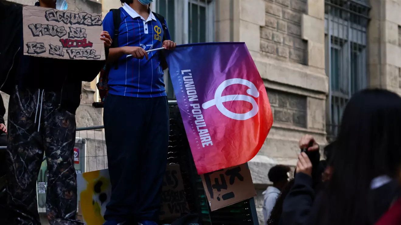 A student holds a flag of La France Insoumise (France Unbowed - LFI) party as French high school students gather outside the Lycee Voltaire high school as part of nationwide protests to demand the hiring of substitute teachers, increased resources and better learning conditions, in Paris, as more than 400 schools remain closed following days of student protests that have escalated into violence in some places, France, October 2, 2026. Reuters/Sarah Meyssonnier