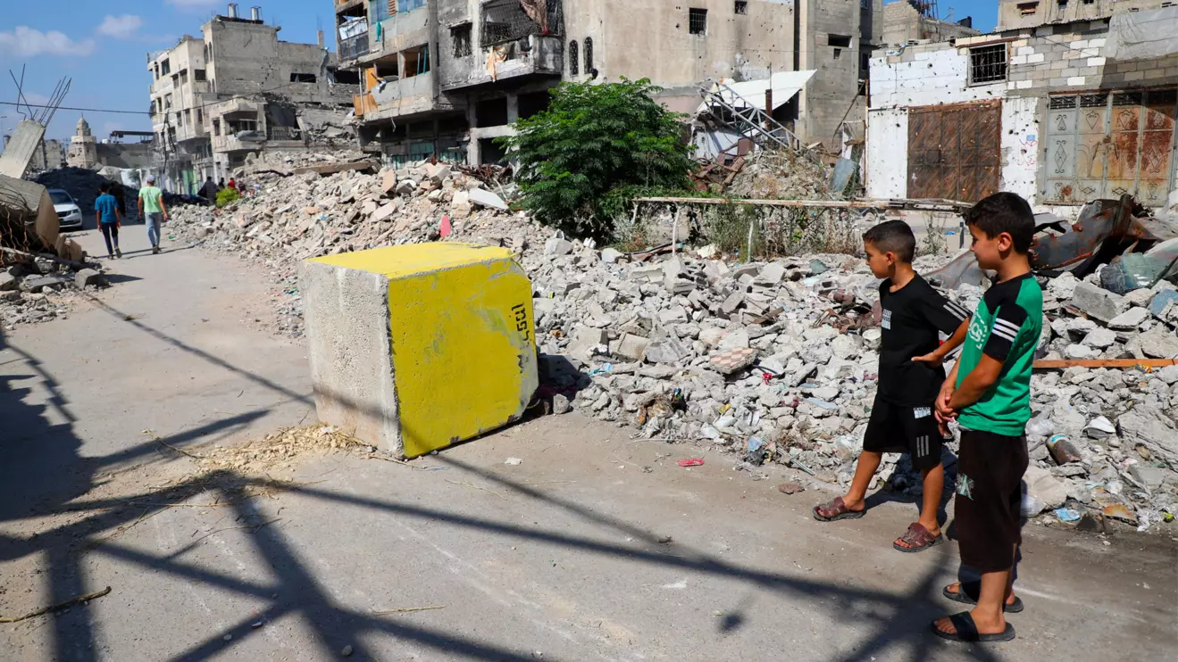 Palestinian boys look at a yellow concrete block marking the "yellow zone" under Israeli military control, in Tufah neighborhood, in Gaza City, July 27, 2026. Reuters/Ebrahim Hajjaj
