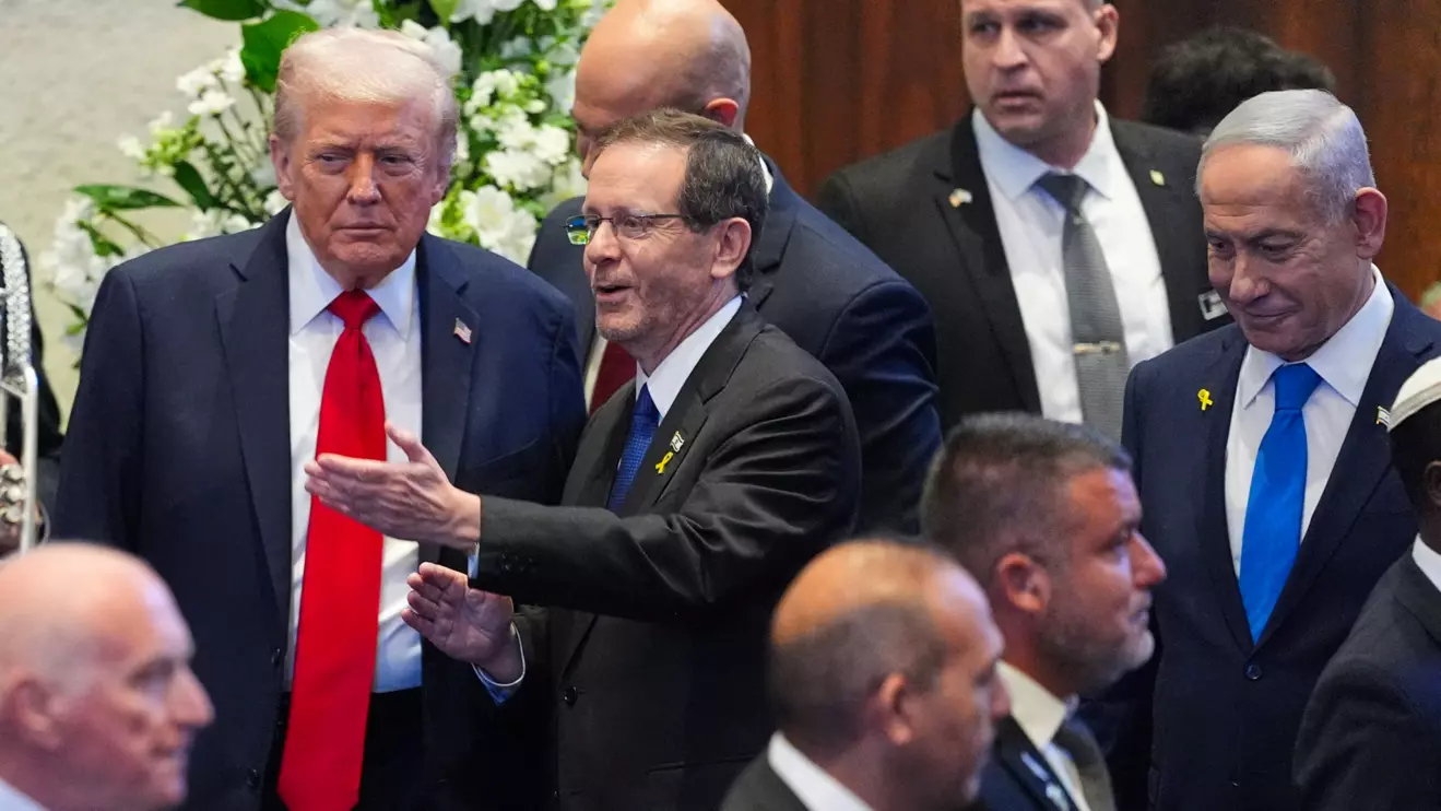 U.S. President Donald Trump enters the Knesset, with Israel's President Isaac Herzog and Israel's Prime Minister Benjamin Netanyahu, before he speaks, Monday, Oct. 13, 2025, in Jerusalem. Evan Vucci/Reuters 