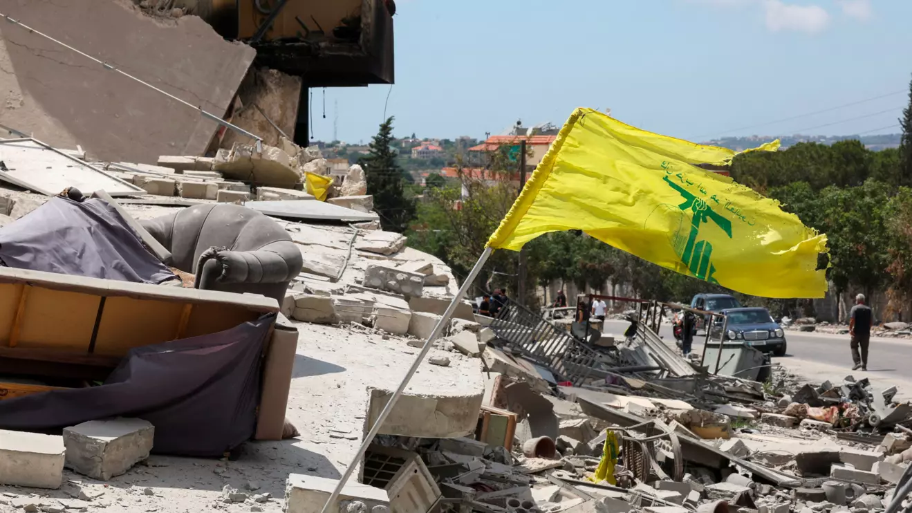 A Hezbollah flag flutters amid rubble of destroyed buildings, in Deir Qanoun al-Nahr, Tyre district, southern Lebanon, June 15, 2026. Reuters/Aziz Taher
