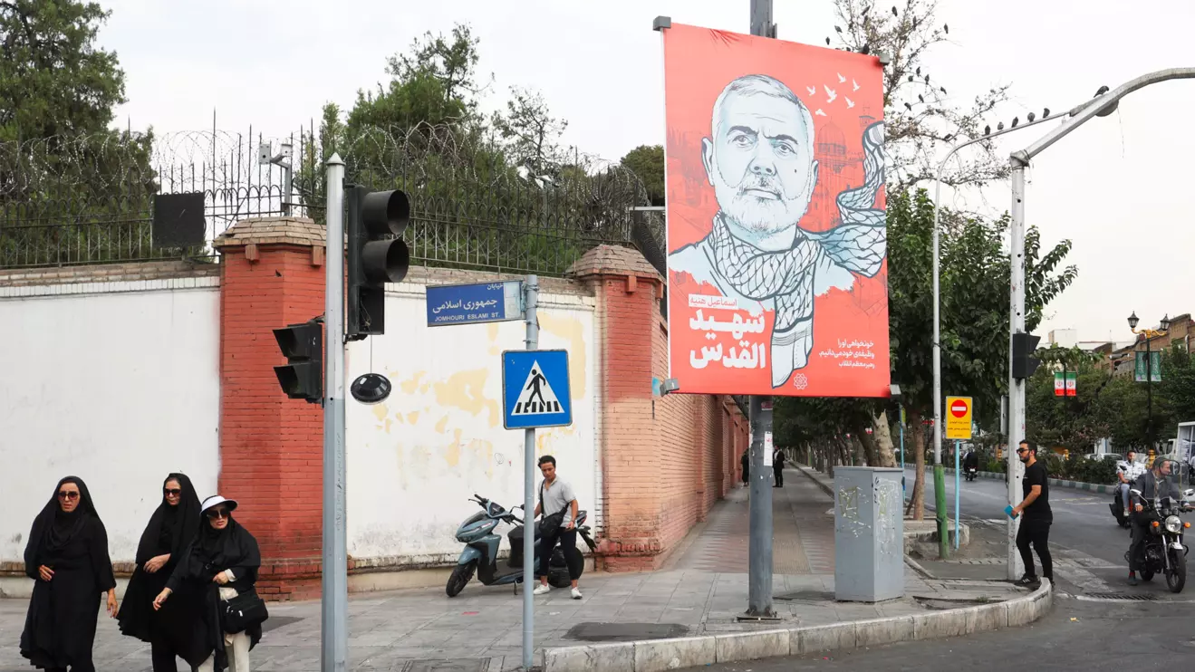 People walk past a banner with a picture of late Hamas leader Ismail Haniyeh in a street in Tehran, Iran, August 12, 2024. Majid Asgaripour/WANA (West Asia News Agency) via Reuters