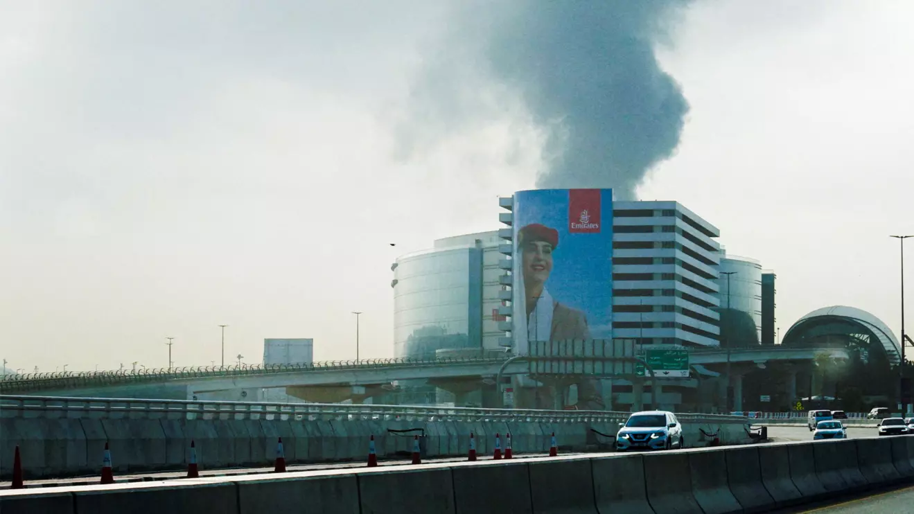 Smoke rising from an area near the Dubai International Airport is seen through the windshield of a vehicle, after a drone attack hit a fuel tank, according to Dubai authorities, amid the U.S.-Israel conflict with Iran, in Dubai, United Arab Emirates, March 16, 2026, Reuters