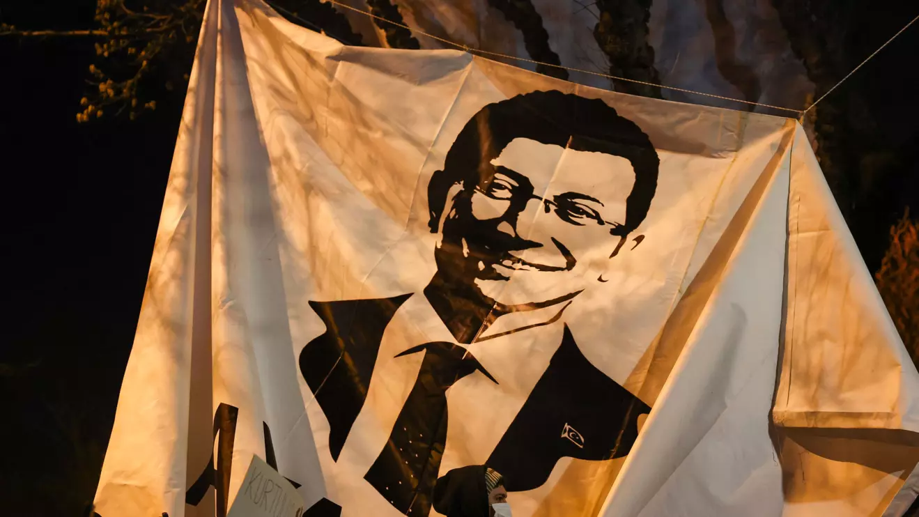 A person walks past a banner with an image of Istanbul Mayor Ekrem Imamoglu, as people take part in a protest against the detention of Imamoglu, in Istanbul, Turkey, March 20, 2025. Reuters/Umit Bektas