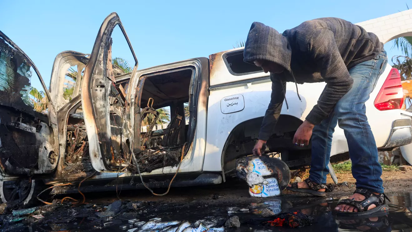 A Palestinian inspects near a vehicle where employees from the World Central Kitchen (WCK),  were killed, Deir Al-Balah, April 2, 2024. Reuters/Ahmed Zakot