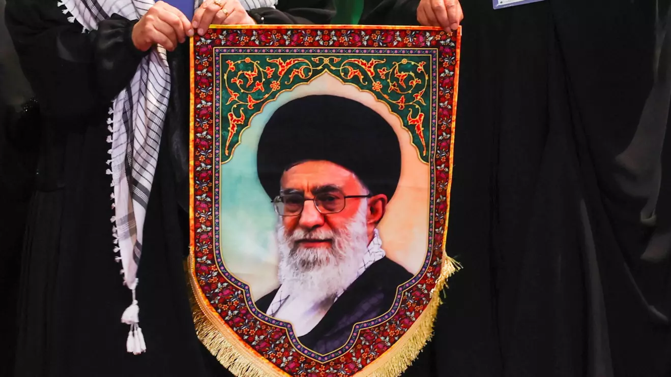 Women hold an image of Iran's late Supreme Leader Ayatollah Ali Khamenei as they walk to pay their respects near the coffins of Khamenei and his family members, on the day international delegates participate in a farewell ceremony for Khamenei, who was killed on February 28 during Israeli and U.S. airstrikes on Iran, at the Imam Khomeini Grand Mosalla in Tehran, Iran July 3, 2026. Reuters/Mohammed Salem