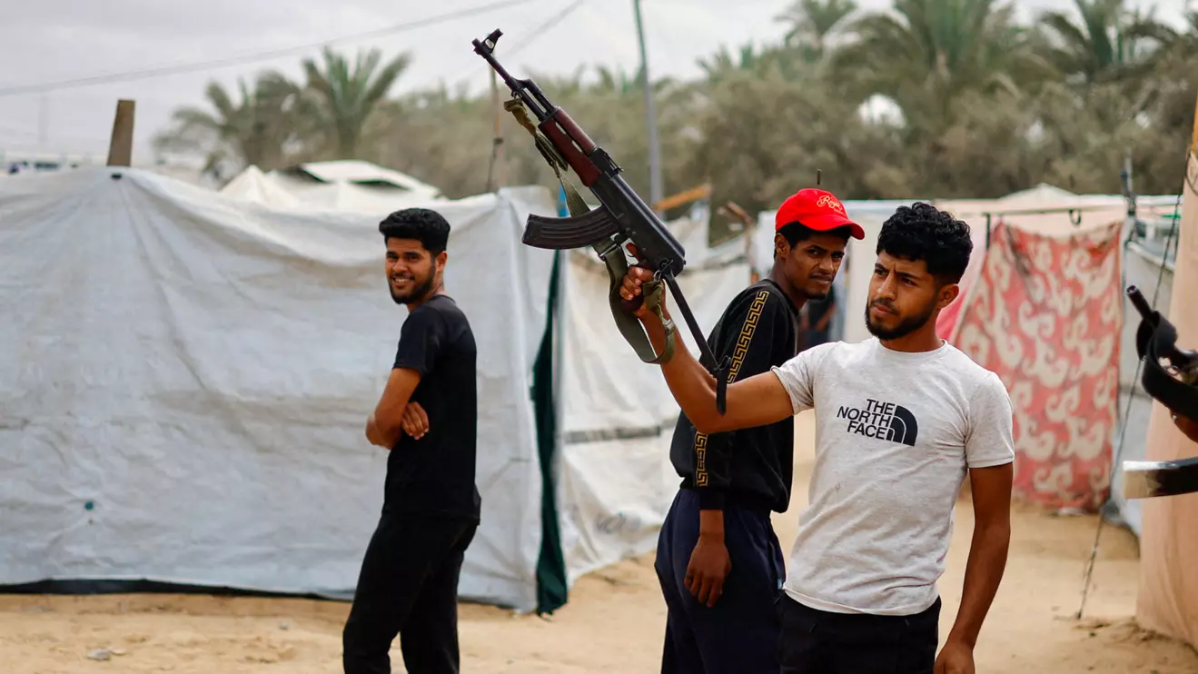 A Palestinian man points a weapon in the air after it was announced that Israel and Hamas agreed on the first phase of a Gaza ceasefire, in the central Gaza Strip, October 9. Reuters/Mahmoud Issa