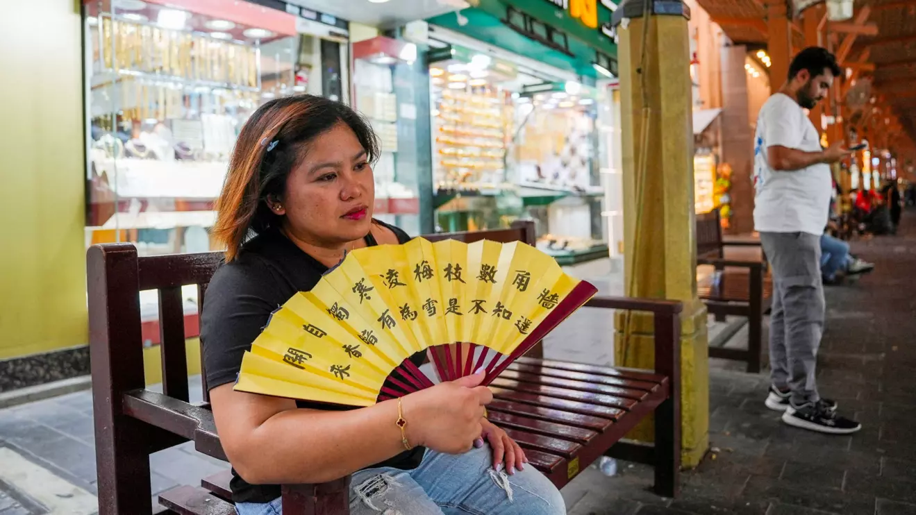 A woman uses a handheld fan during a heatwave in Dubai, United Arab Emirates, Reuters/Raghed Waked