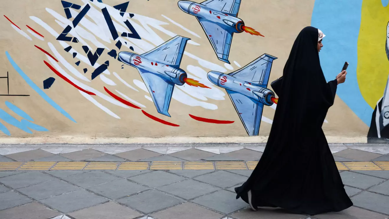 A woman walks next to an anti-Israeli mural on a street, amid a ceasefire between U.S. and Iran, in Tehran, Iran, April 20, 2026. Majid Asgaripour/WANA via Reuters
