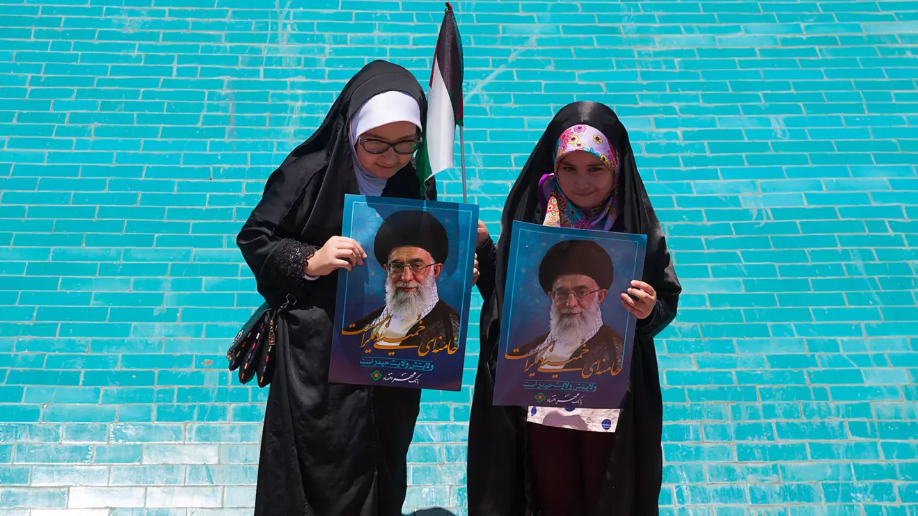 Two little girls holding Ali Khamenei's photo © Mena Today 