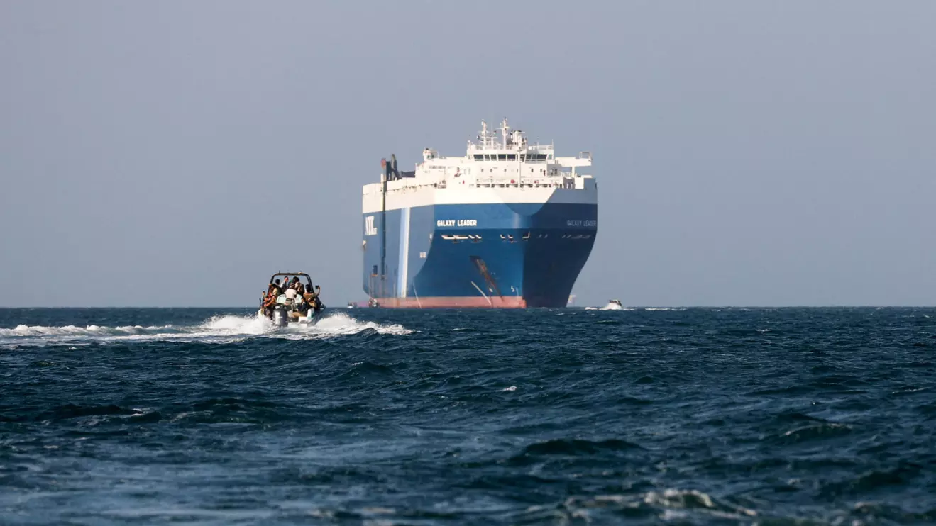 A boat carrying people sails near the Galaxy Leader commercial ship, seized by Yemen's Houthis last month, off the coast of al-Salif, Yemen, December 5, 2023. Reuters/Khaled Abdullah