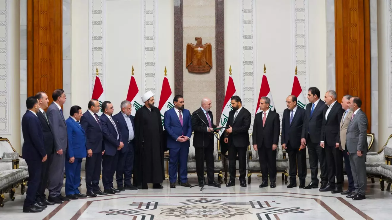 Iraqi President Nizar Amedi and Ali al-Zaidi, the nominee of Iraq's Shiite Coordination Framework for prime minister, stand with political figures during a ceremony where Zaidi was tasked with forming a new government, in Baghdad, Iraq, April 27, 2026. Iraqi President Media Office/Handout via Reuters