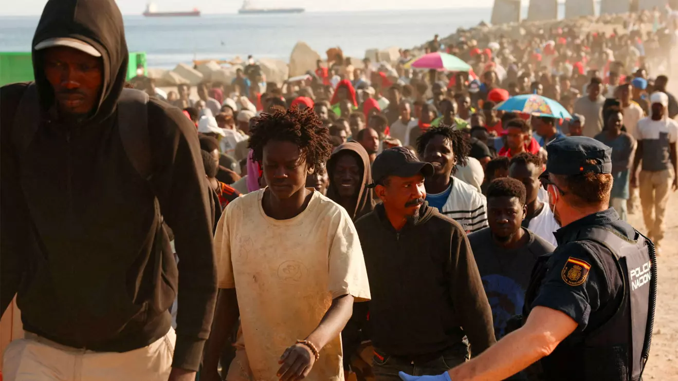 Migrants are escorted from a makeshift beach camp to official shelters across the city after authorities cleared the site, following a mass crossing from Morocco, in Spain's North African enclave of Ceuta, August 20, 2026. Reuters/Violeta Santos Moura