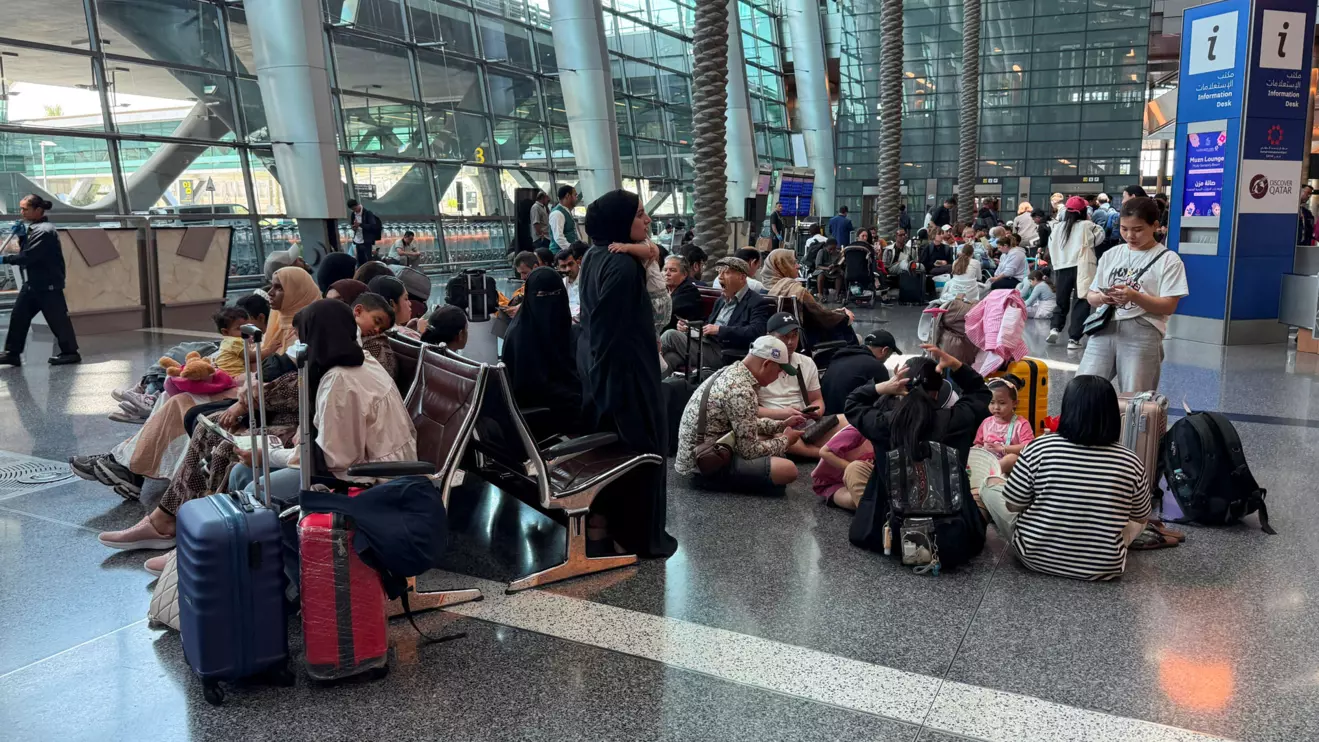 People sit at Hamad International Airport after Qatar reopened its airspace following a brief closure in the wake of Iran’s missile attack on Al Udeid Air Base on Monday, in Doha, Qatar, June 24, 2025. Reuters