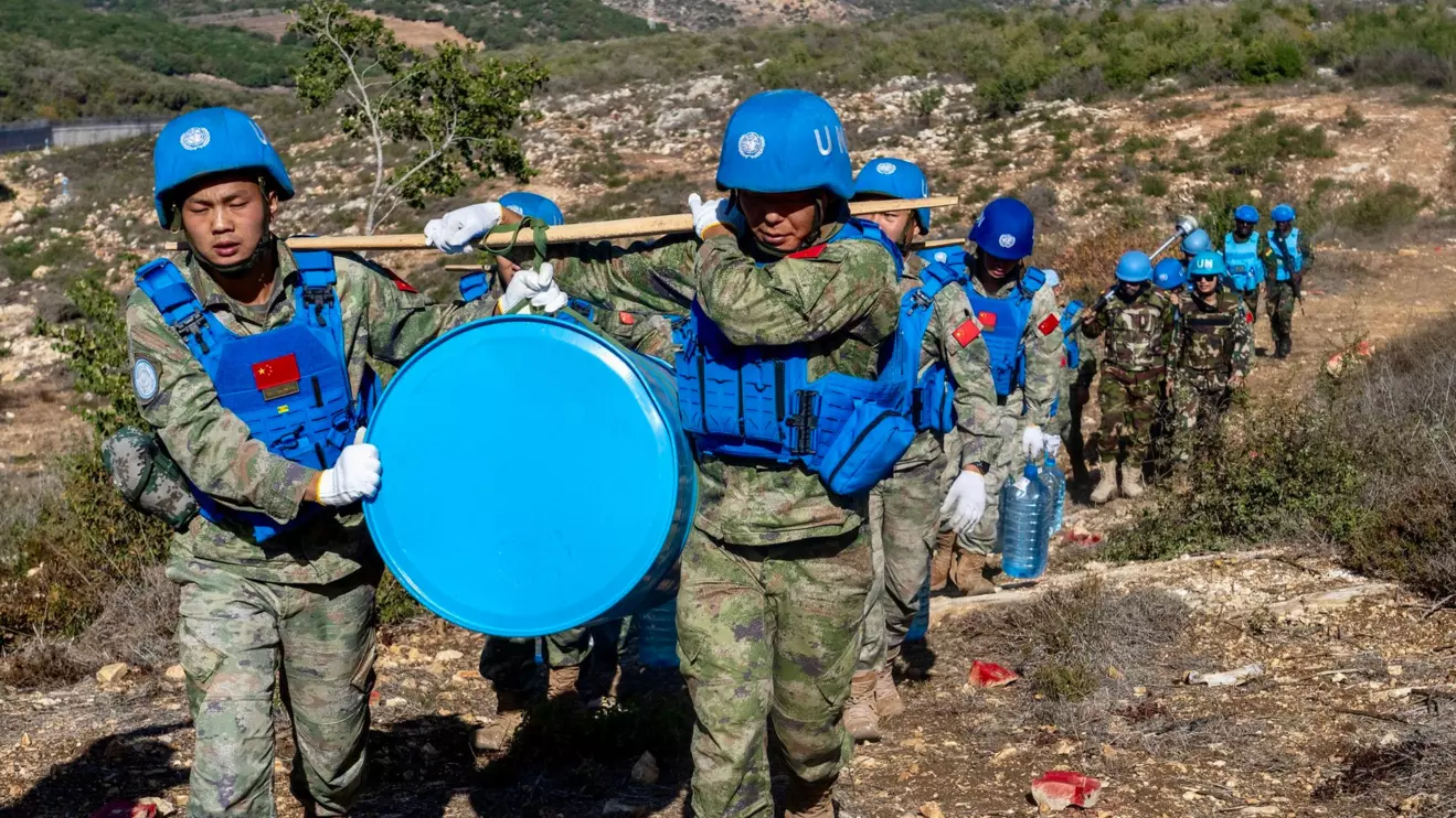 During one such refurbishment mission on 22 October, southwest of the village of Rmeich, dozens of Chinese peacekeepers carried a new blue barrel and construction materials © UNIFIL