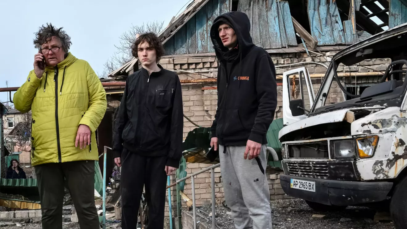 Residents stand near their building hit by a Russian drone strike, amid Russia's attack on Ukraine, in Zaporizhzhia, Ukraine March 21, 2026. Reuters
