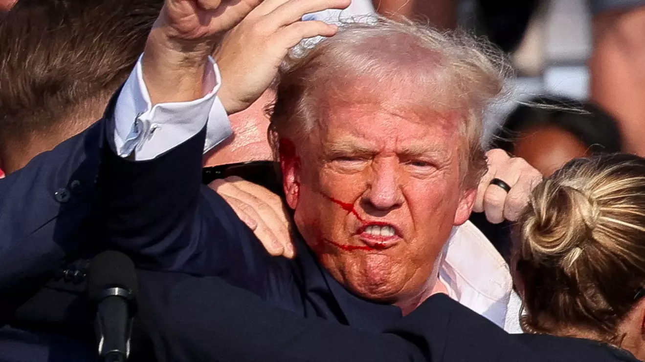 Republican presidential candidate and former U.S. President Donald Trump is assisted by the Secret Service after gunfire rang out during a campaign rally at the Butler Farm Show in Butler, Pennsylvania, U.S., July 13, 2024. Reuters/Brendan McDermid