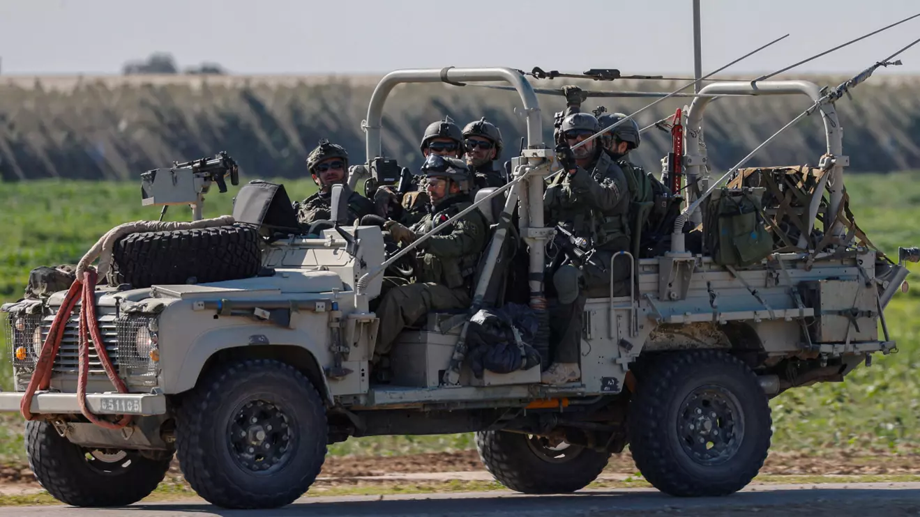 Israeli soldiers ride a military vehicle as they leave Gaza, amid the ongoing conflict between Israel and the Palestinian Islamist group Hamas, as seen from southern Israel, January 13, 2024. Reuters/Tyrone Siu