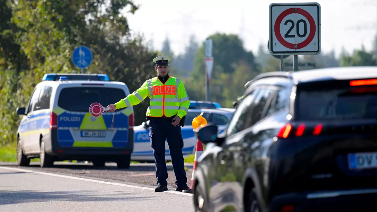 A police officer holds a stop sign at a border with Denmark, as all German land borders are subject to random controls to protect internal security and reduce irregular migration, in Boeglum, Germany, September 16, 2024. Reuters/Fabian Bimmer
