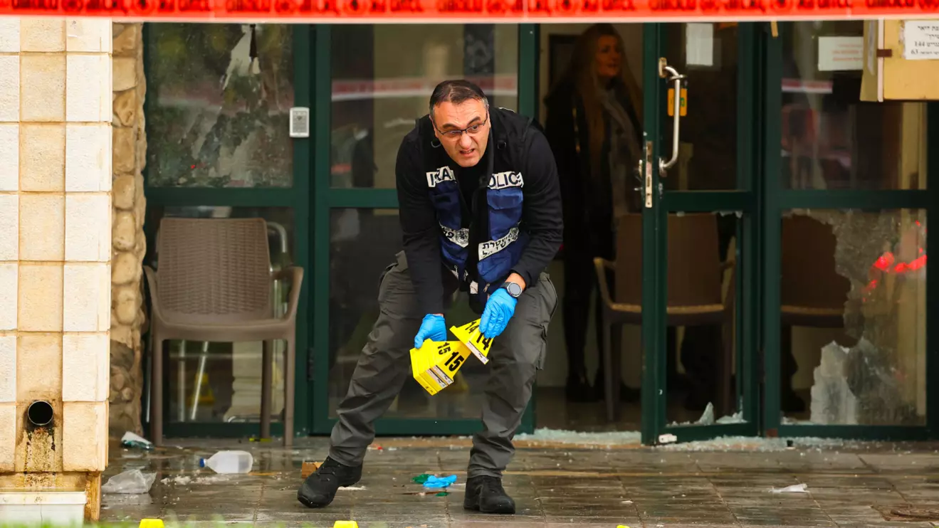 A member of the Israeli police holds markers at the scene of a suspected attack near Herzliya, Israel, December 27, 2024. Reuters/Kai Pfaffenbach