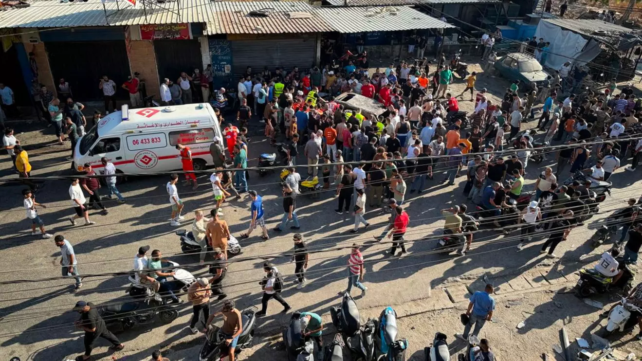 People gather near a damaged car after the Israeli military said in a statement it struck a "key" figure from Palestinian militant group Hamas, in Ayrounieh, northern Lebanon July 8, 2025. Reuters/Walid Saleh