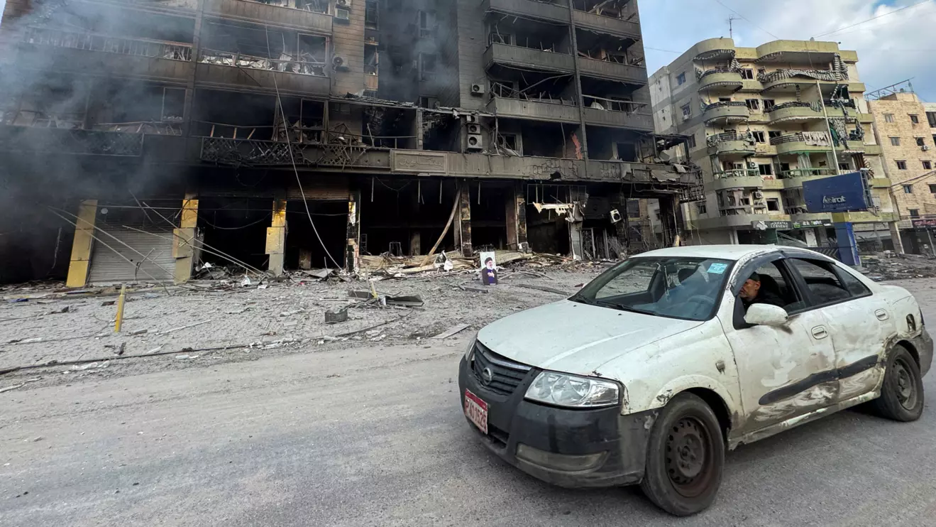 A car drives past burned buildings after an Israeli strike on Beirut's southern suburbs, following an escalation between Hezbollah and Israel amid the U.S.-Israeli conflict with Iran, Lebanon, March 7, 2026. Picture taken with a mobile phone. Reuters