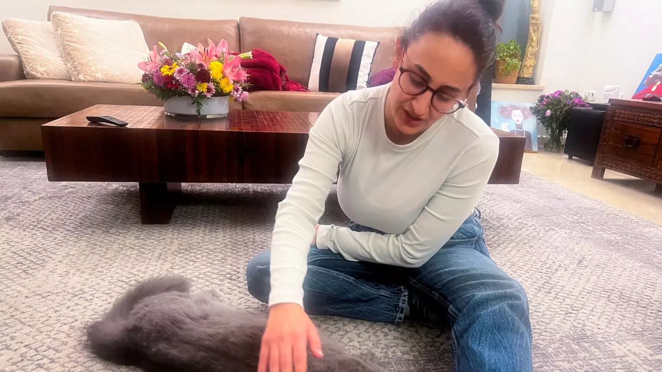 Sharon Alony-Cunio, who was kidnapped with her daughters Emma and Julie and husband David Cunio in the deadly October 7 attack by Palestinian Islamist group Hamas, pets a cat as she attends an interview with Reuters, amid the ongoing conflict between Israel and Hamas in Gaza Strip, in Yavne, Israel, December 10, 2023. Reuters/Eli Berlzon