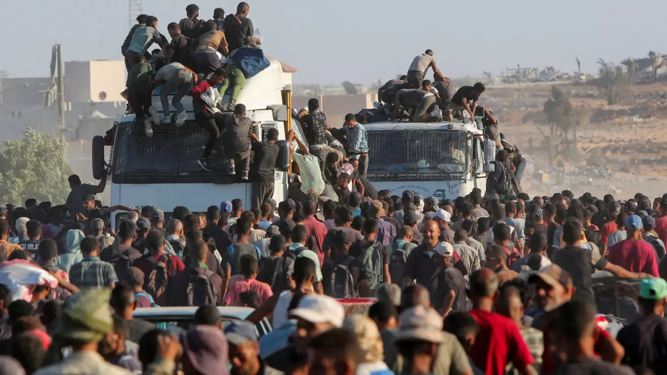 Palestinians climb onto trucks as they seek aid supplies in Khan Younis, southern Gaza Strip, August 4, 2025. Reuters/Hatem Khaled
