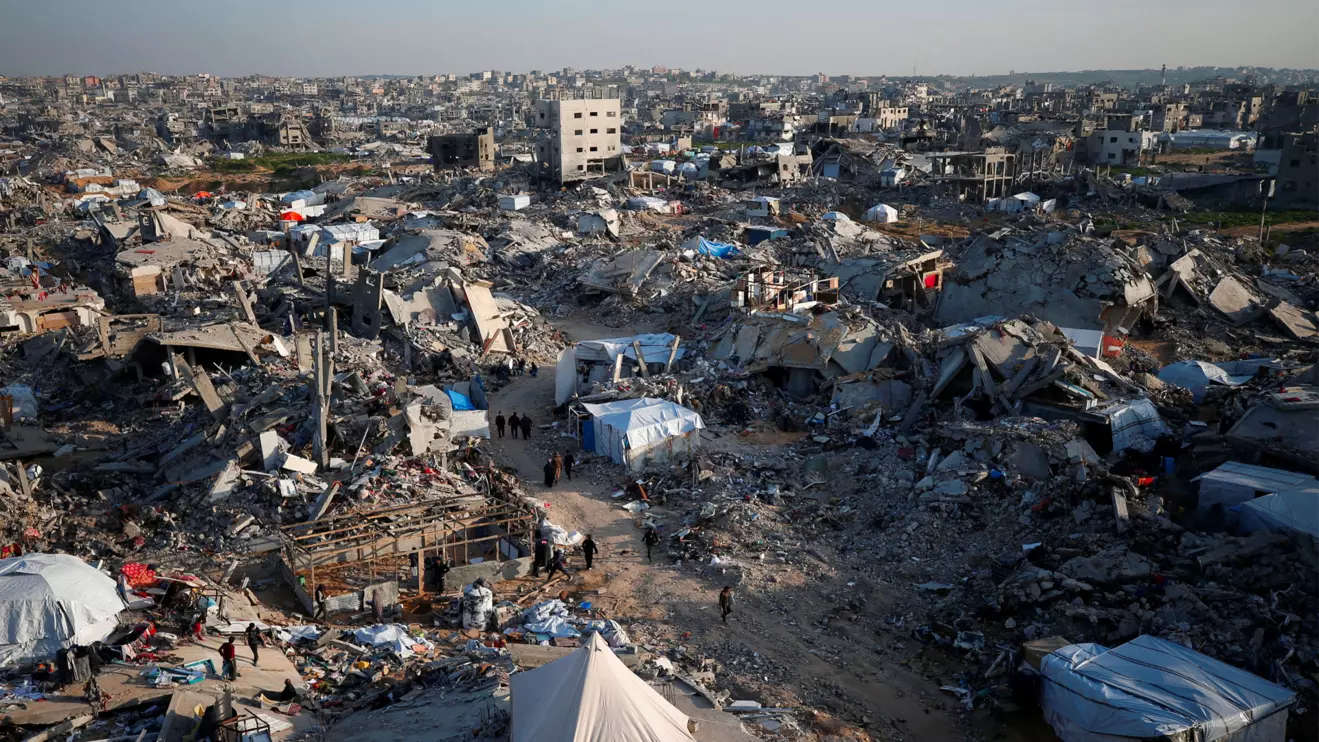 Palestinians walk past the rubble of buildings, amid a ceasefire between Israel and Hamas, in Khan Younis, in the southern Gaza Strip, February 27, 2025. Reuters/Ramadan Abed