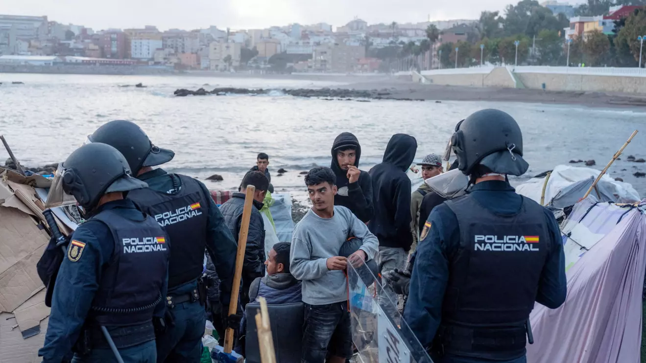 Riot police officers clear part of the makeshift migrant camp at Benitez beach during an operation that, according to police, aims to establish a security perimeter around Ceuta's desalination plant, following the mass crossing of migrants from Morocco, in Ceuta, Spain, September 27, 2026. Reuters/Manu Brabo