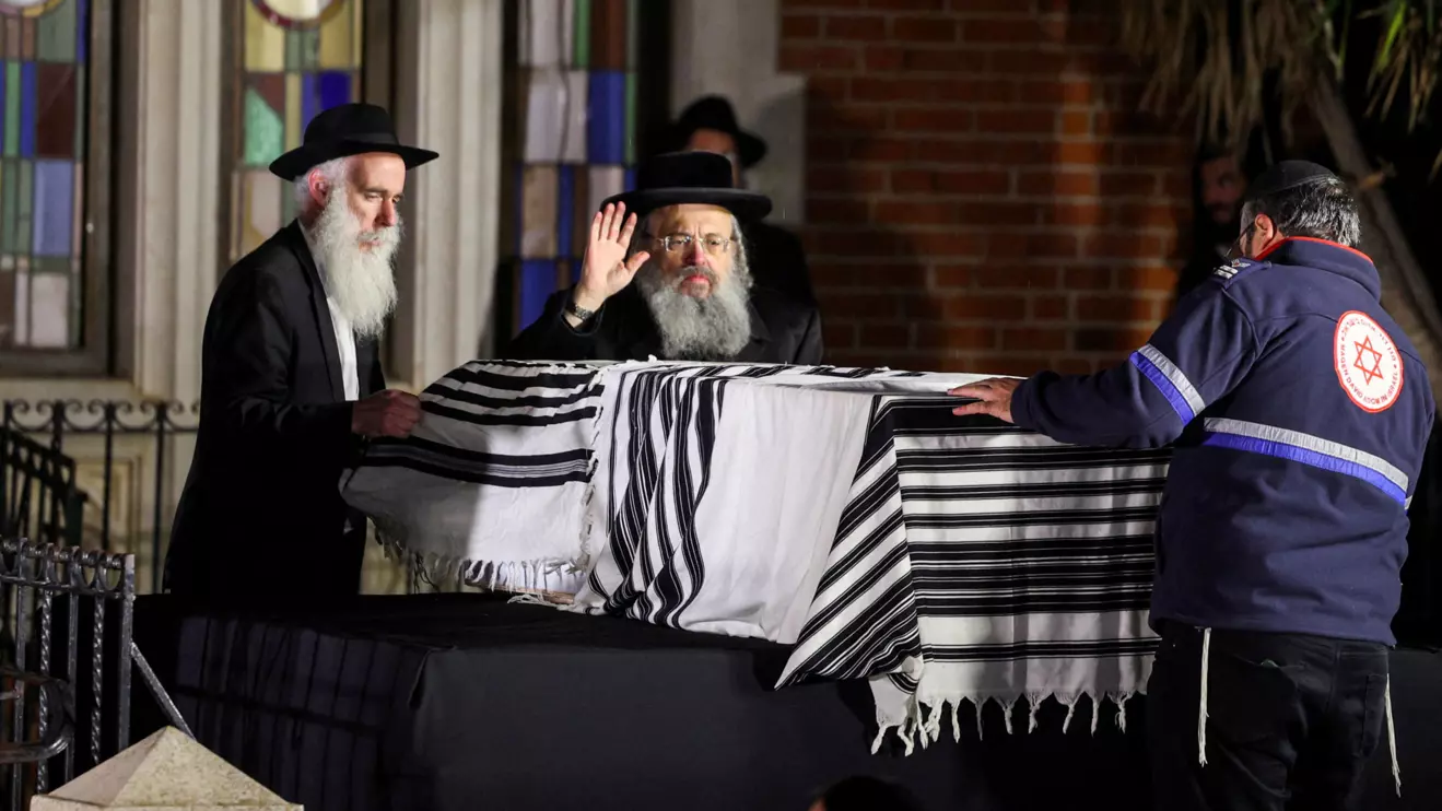 People stand next to the coffin of Israeli rabbi, Zvi Kogan, who was found murdered in the United Arab Emirates, during his funeral, in Kfar Habad, Israel, November 25, 2024. Reuters/Stoyan Nenov