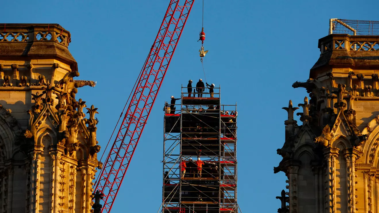 A crane raises the new rooster to install it at the top of the spire of the Notre-Dame de Paris Cathedral, which was ravaged by a fire in 2019 that sent its spire crumbling down, as restoration works continue in Paris, France, December 16, 2023. Reuters/Christian Hartmann