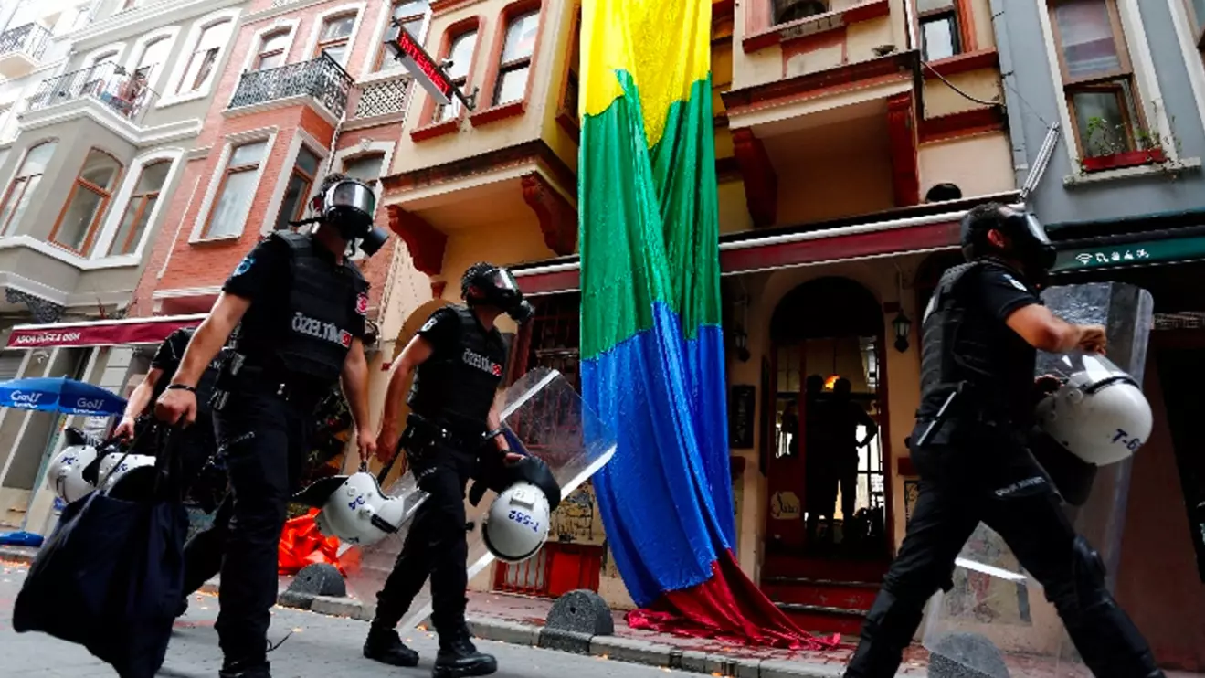 Riot police, with a rainbow flag in the background, chase LGBT rights activists as they try to gather for a pride parade, which was banned by the governorship, in Istanbul, Turkey, June 26, 2016. Reuters/Murad Sezer