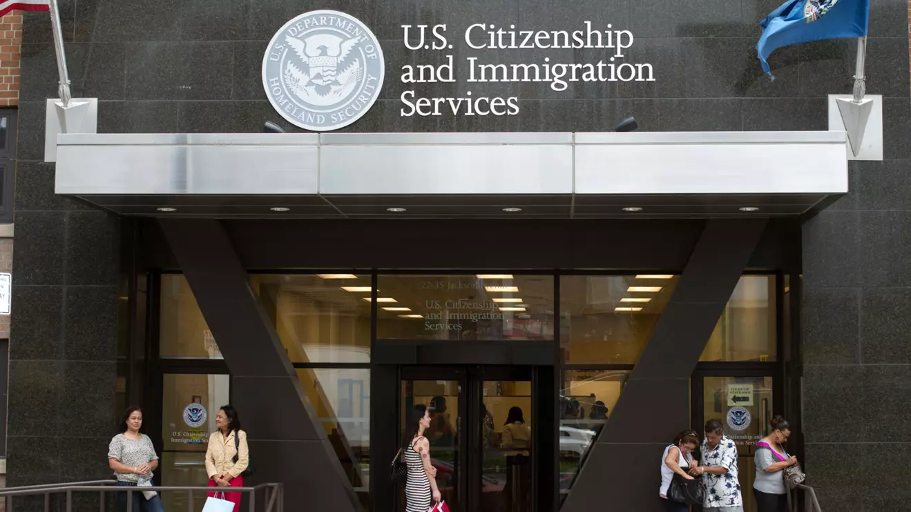 People stand on the steps of the U.S. Citizenship and Immigration Services offices in New York, Reuters/Keith Bedford
