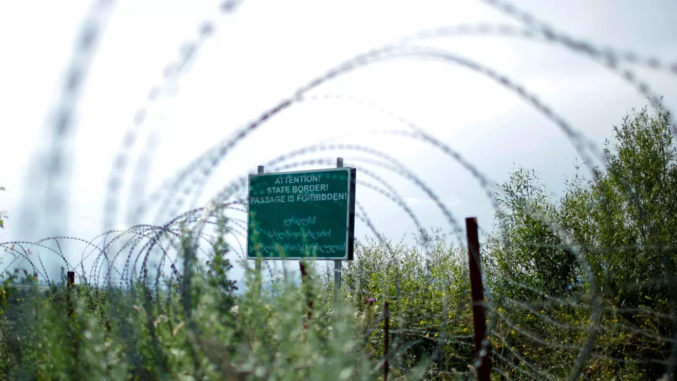A border sign is seen behind the barbed wire at the de facto border of Georgia's breakaway region of South Ossetia in Khurvaleti, Georgia.  Reuters/David Mdzinarishvili