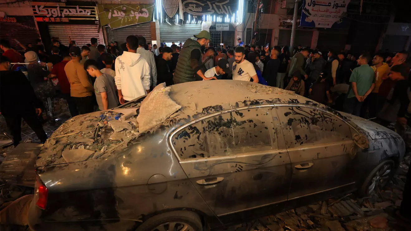 Palestinians stand by a damaged car, at the site of an Israeli airstrike on a residential building in Gaza City, May 26, 2026. Reuters/Dawoud Abu Alkas