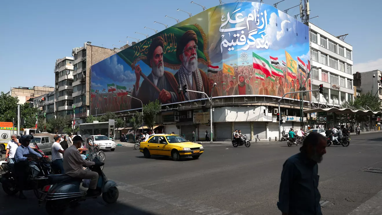 People walk past a billboard depicting the late leader of the Islamic Revolution, Ayatollah Ruhollah Khomeini, and the late Iran's Supreme Leader Ayatollah Ali Khamenei, on a street in Tehran, Iran, June 10, 2026. Majid Asgaripour/WANA (West Asia News Agency) via Reuters
