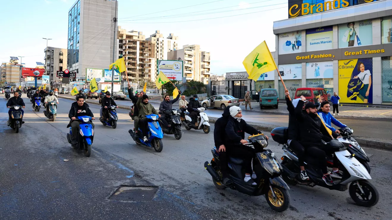 Men carry Hezbollah flags while riding on two wheelers, at the entrance of Beirut's southern suburbs, in Lebanon, November 27, 2024. Reuters/Thaier Al-Sudani