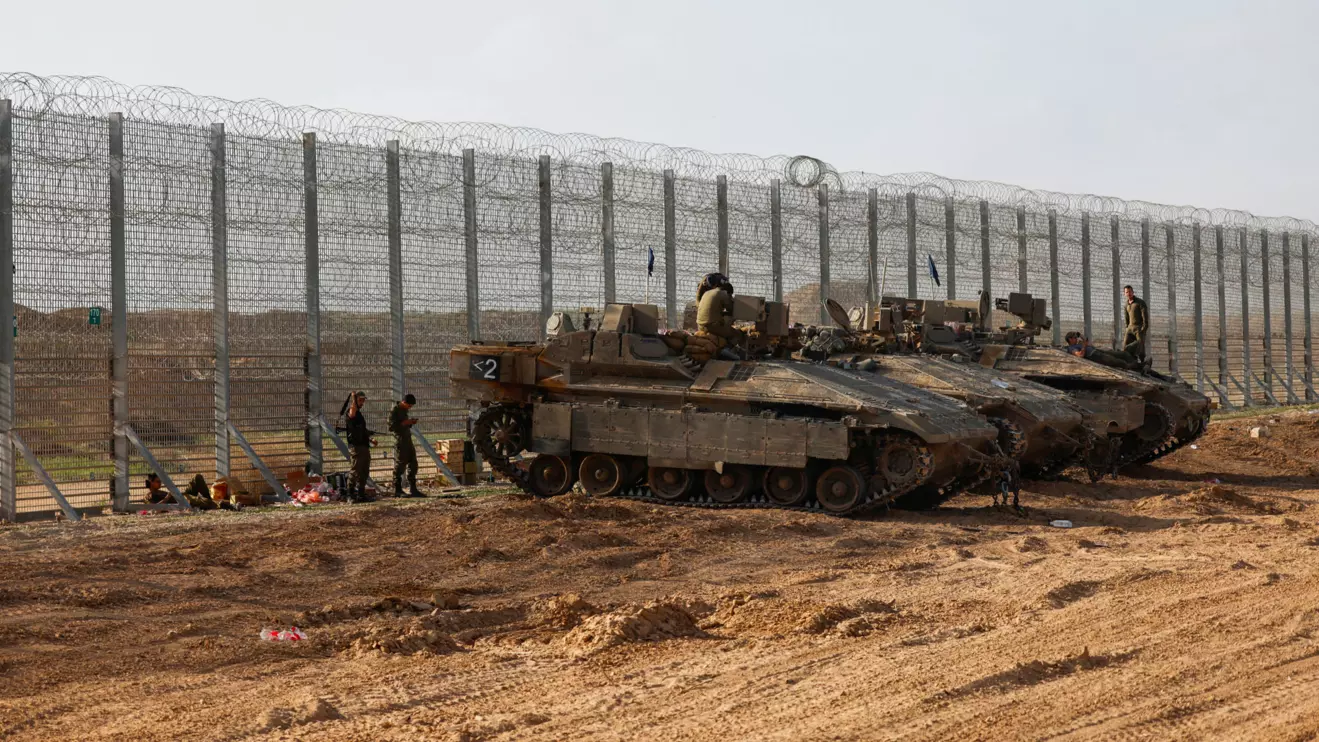 Soldiers sit on top of APC's, at the Israel-Gaza border, Reuters/Amir Cohen